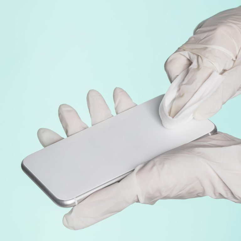 hands-with-surgical-gloves-cleaning-smartphone
